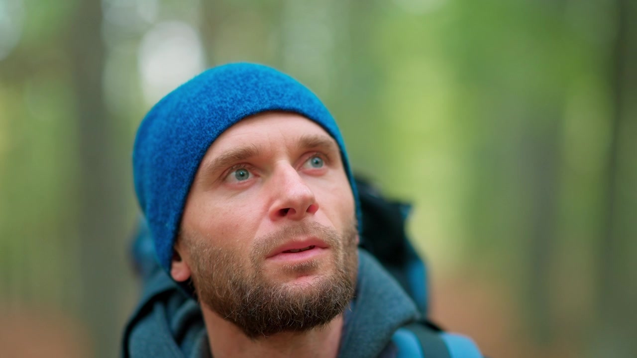 Close-up of a Thoughtful Hiker Looking Up in a Green Forest