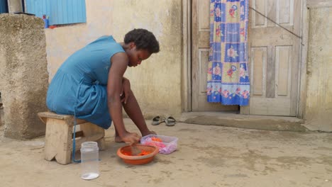 Mujer-Africana-Triturando-Verduras-Para-Comer-Con-Banku,-Bola-De-Masa-De-Harina-Con-Levadura,-Plato-Típico-De-Ghana