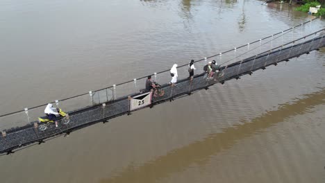 portrait human interest with people walking on the bridge martapura river banjarmasin. river water overflows in the rainy season