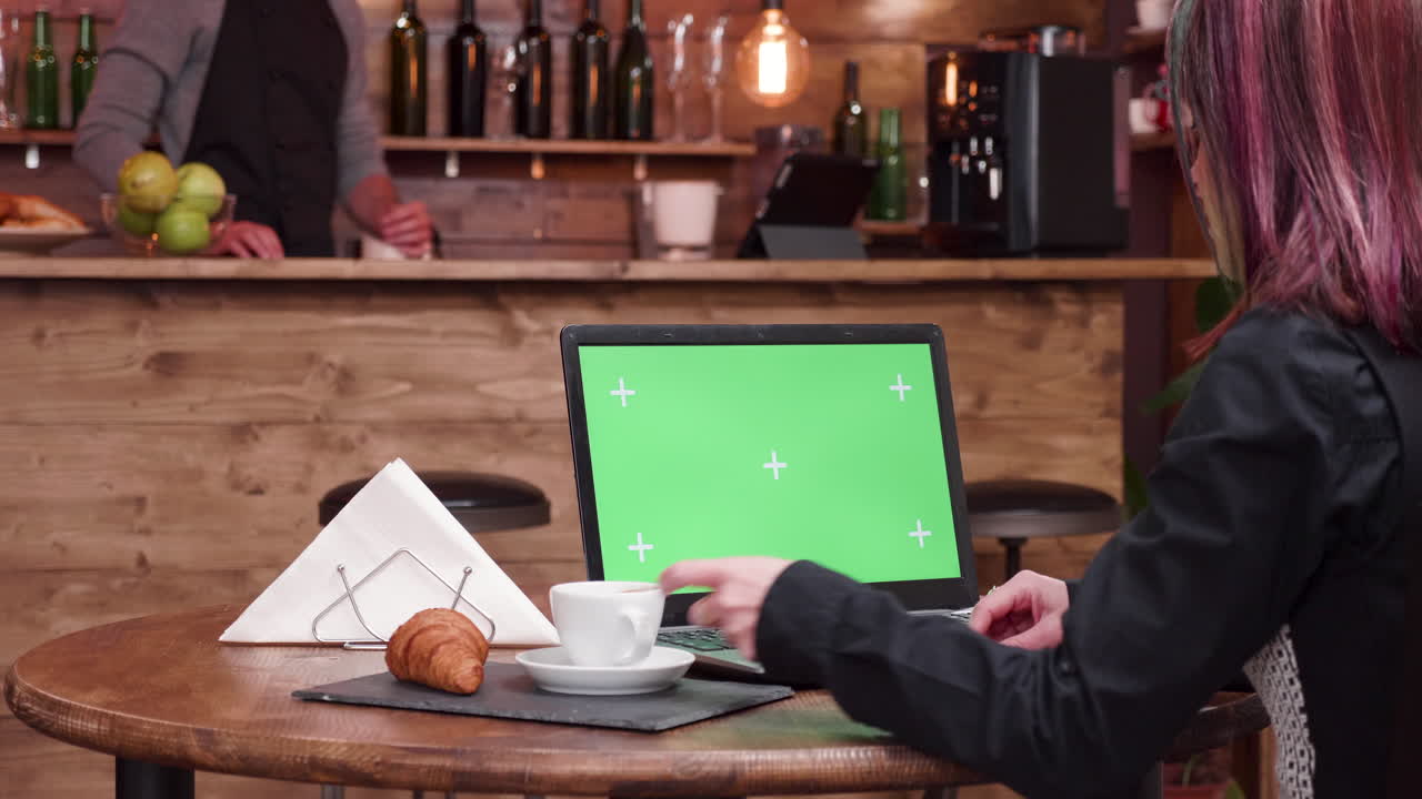 mujer usando una computadora portátil en un café