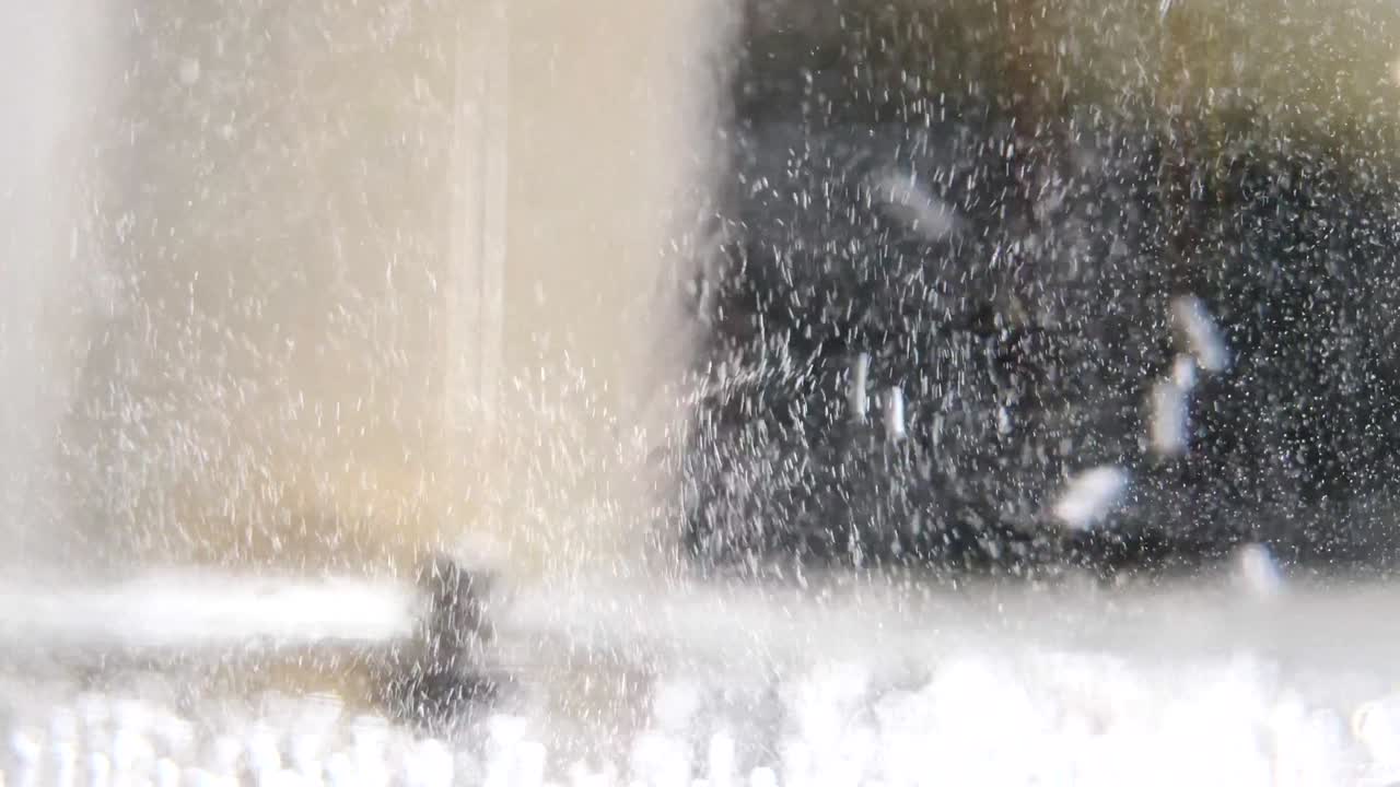 뜨거워지면 물에 떠다니는 티니 거품의 클로즈업, 4k, 느린 동작.