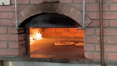 Pizza-margarita-pepperoni-beef-steak-are-baking-in-the-hot-firewood-oven-with-brick-structure-in-a-big-mall-or-local-traditional-market-with-handmade-dough-and-delicious-taste-spicy-mamma-mia