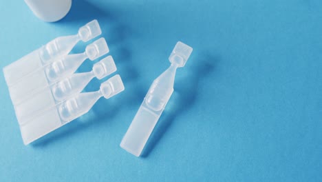 Video-of-saline-caplets-and-dropper-bottle-on-blue-background-with-copy-space