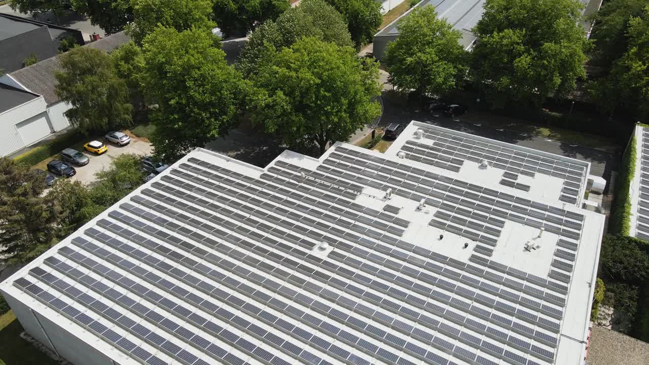Beautiful aerial of solar panels on the rooftop of a large industrial building on a sunny day