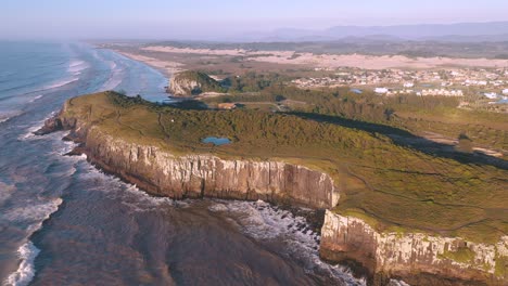 cinematic aerial view of high cliffs on atlantic ocean, guarita park, brazilian conservation unit located in the southern region, state of rio grande do sul, torres city