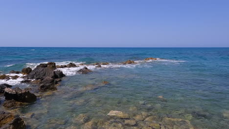 the turquoise sea spills onto the beach of crete