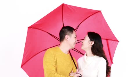 happy couple kissing undern an umbrella