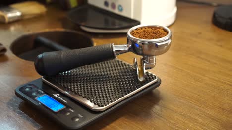 SLOWNO---Professional-female-barista-checks-ground-coffee-in-portafilter-on-scale