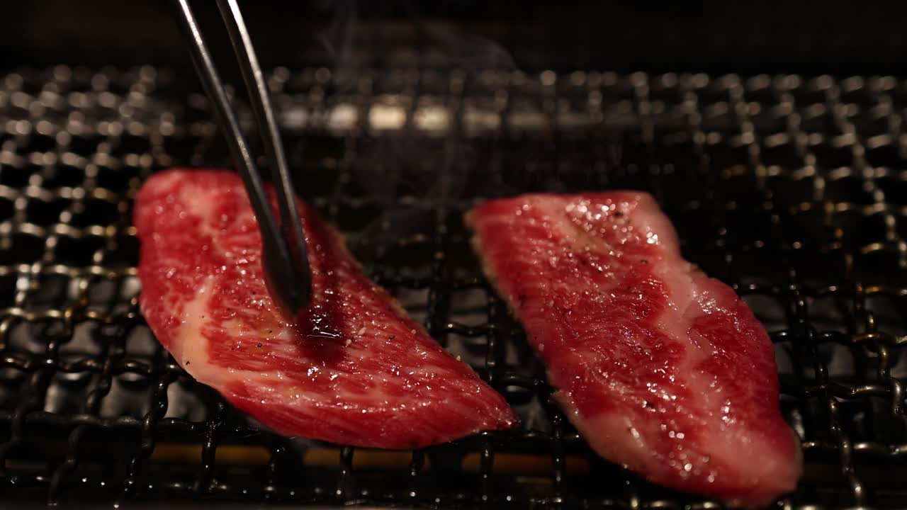 Sizzling steak being flipped on a grill