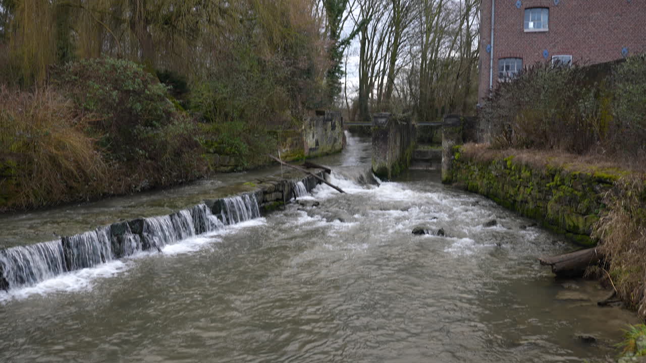 Kleine Wasserstufe nahe alter Wassermühle in Belgien, Blick nach oben.
