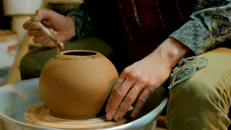 professional male potter working in workshop, studio