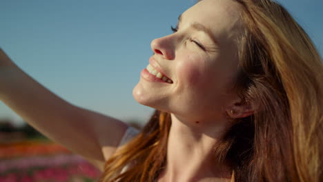 portrait of beautiful woman looking at sun. closeup young woman closing eyes.