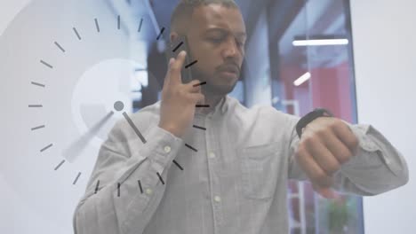 Animation-of-clock-over-african-american-businessman-talking-on-smartphone