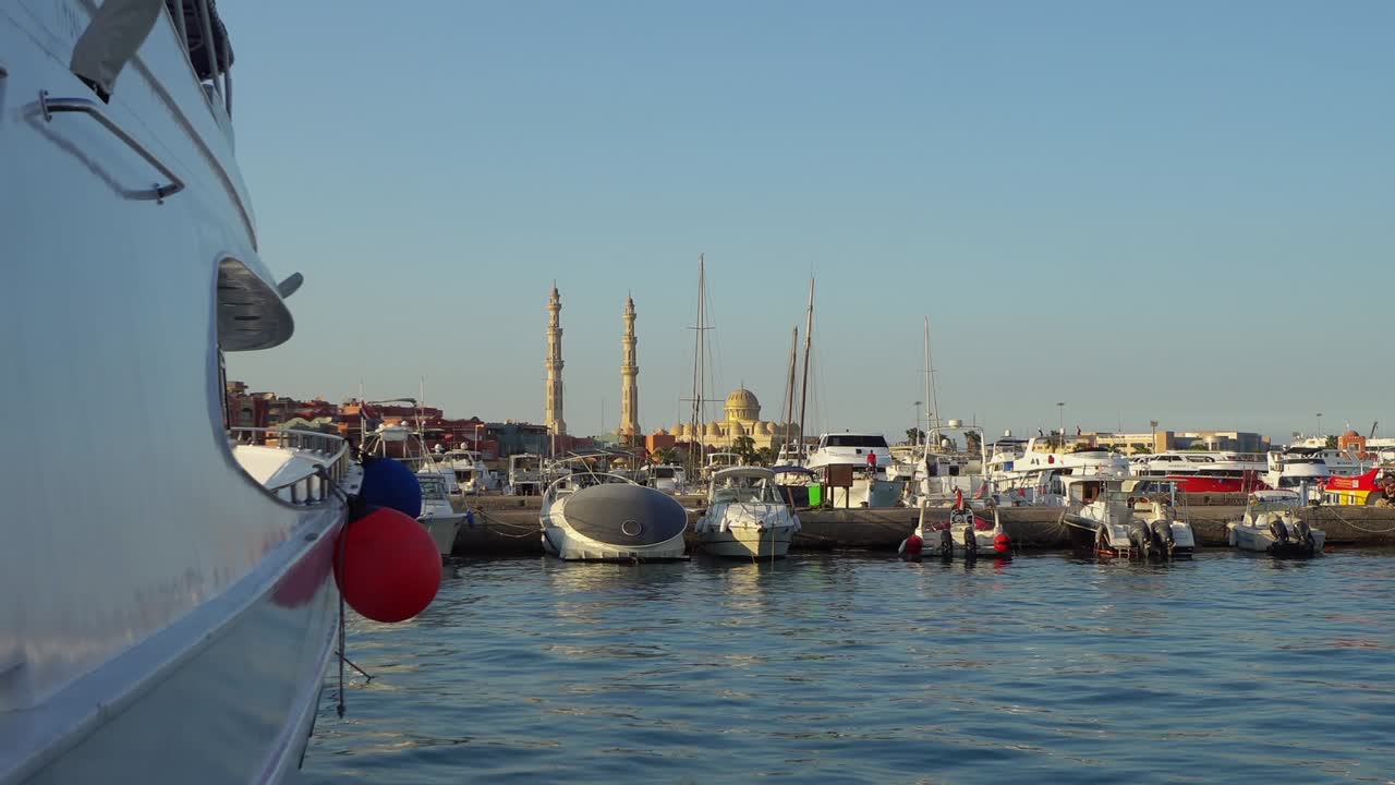 은 바다와 엘 미나 모스크를 배경으로 한 다채로운 마리나 산책 거리에 럭셔리 요트가 있는 허르가다 항구