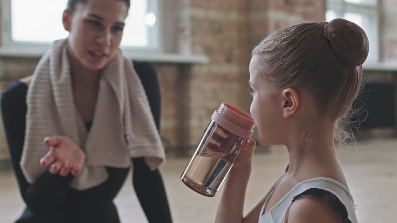 Adult And Small Ballerinas Talking After Ballet Training