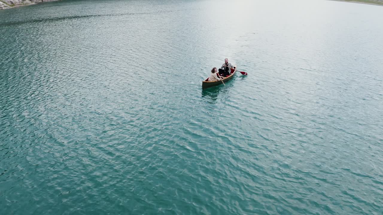 Coppia in canoa su un lago sereno.