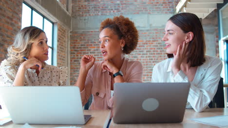 Female-Multi-Cultural-Business-Team-Meeting-Around-Laptop-In-Office