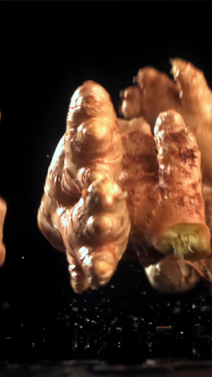 Radice di zenzero fresco che cade e schizza al rallentatore.