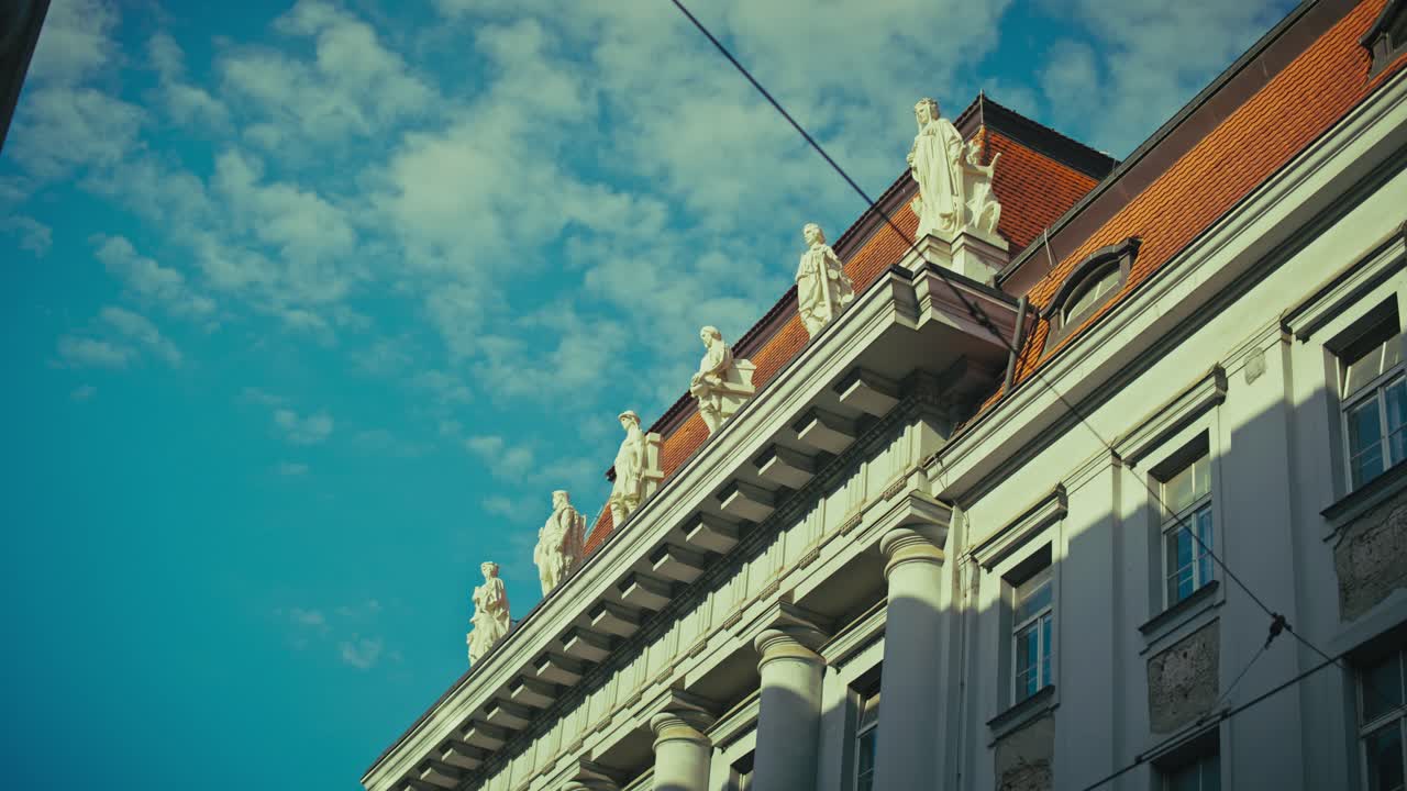 Statues and architectural details atop a historic building in Zagreb