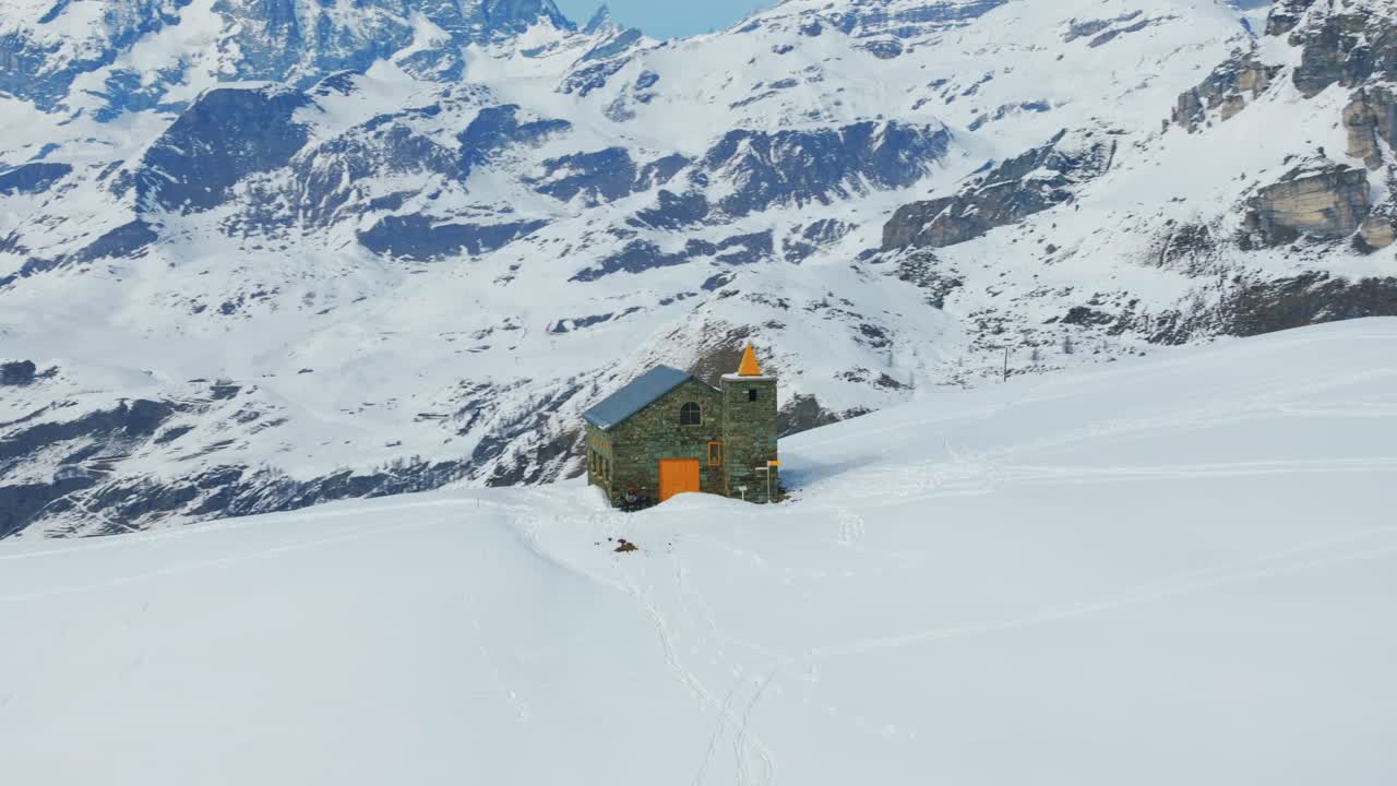 Santuario Clavalité in snowy landscape, Alps, Cheneil, Valle d'Aosta in Italy. Aerial drone orbiting