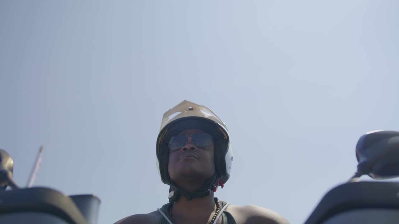hombre negro conduciendo una motocicleta en la calle, policía de playa, aplicación de la ley, pobreza, 4k | mirando a su alrededor, tembloroso, carretera, viajes, poste de luz, disfrutando de la vida