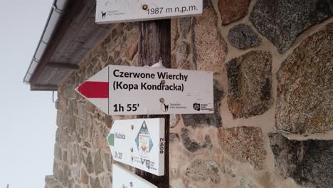 pulling away from mountain route information signpost on snowy polish ski resort summit