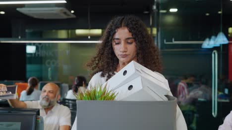 sad indian corporate woman employee leaving the office after losing the job.
