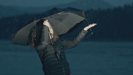 emotional girl with umbrella under night rain slow motion