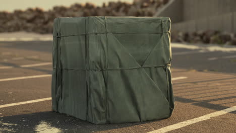 mysterious green covered box in a parking lot