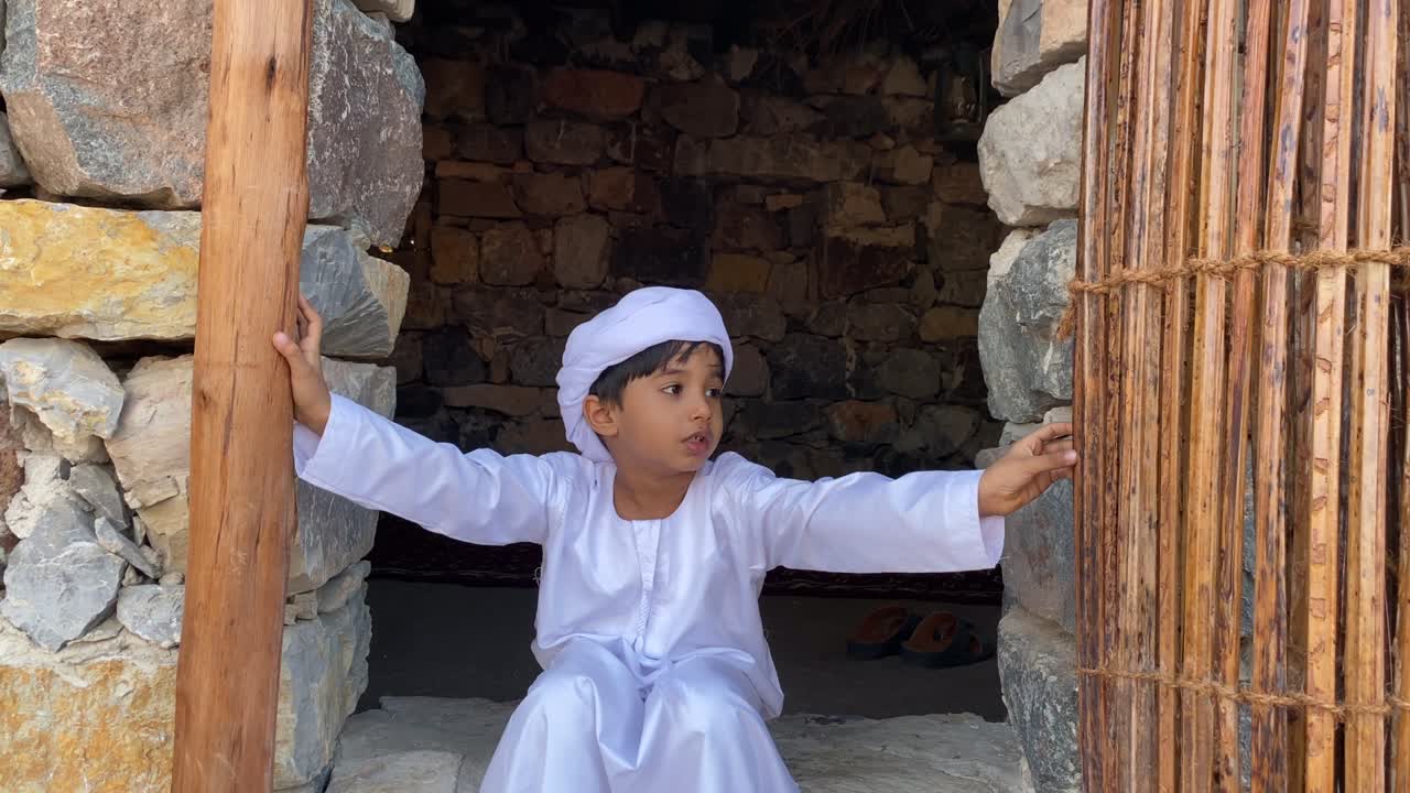 돌로 만든 아라비아의 전통적인 집에서 아랍의 아이