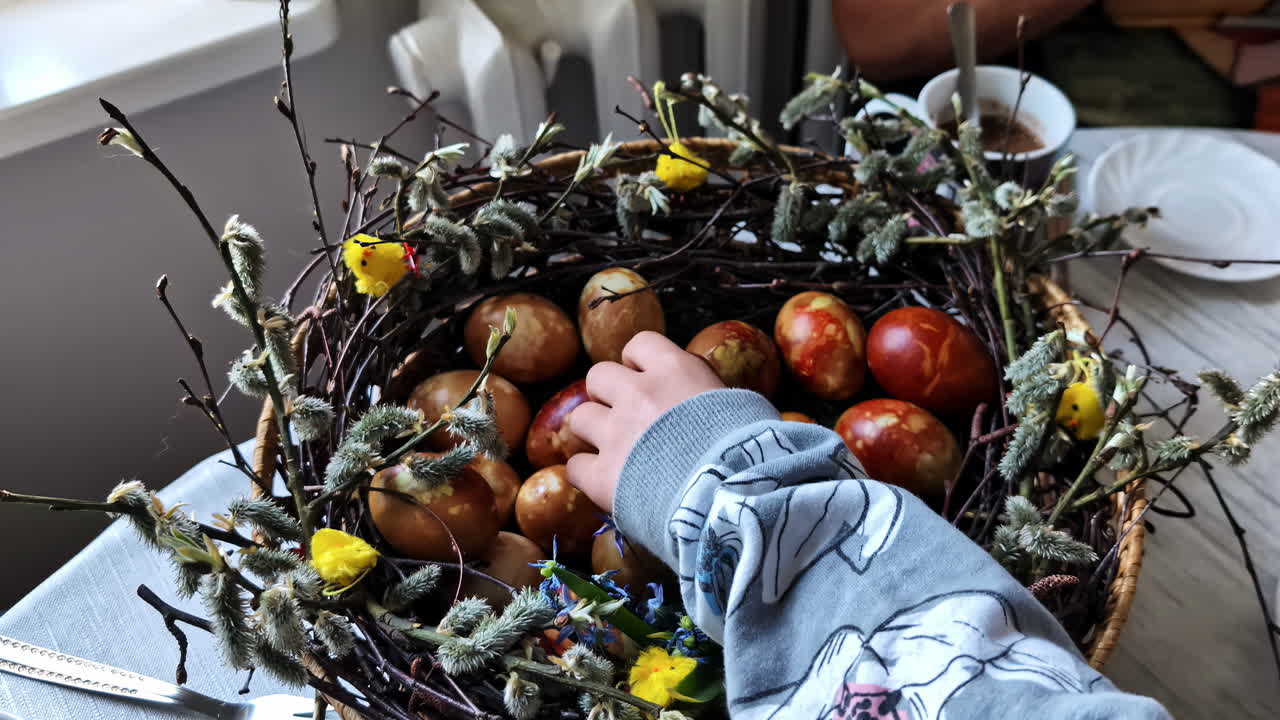 Basket with dyed eggs and hand reaching in Cesis, Latvia, during Easter