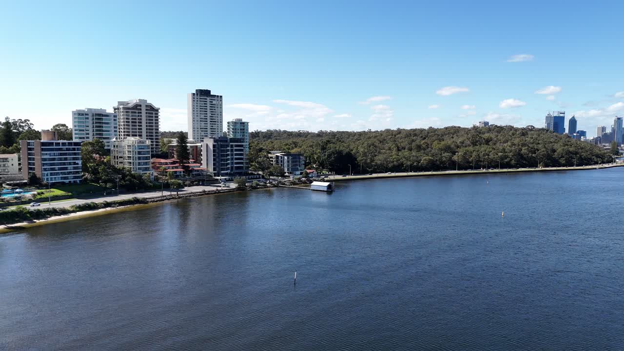 casa de botes azul en perth, australia occidental con el tráfico que pasa en el fondo a lo largo del río swan