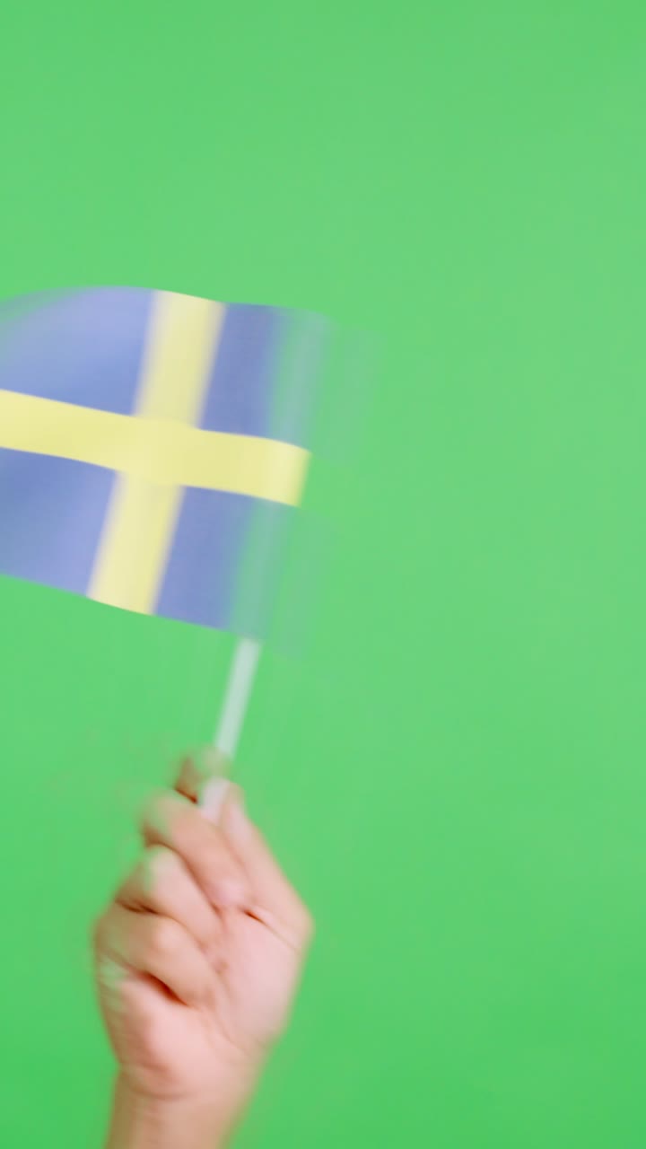Hand waving a pennant of a swedish national flag
