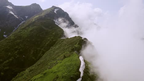 toma aérea cinematográfica sobre los picos de las colinas en la niebla, naturaleza intacta de las montañas