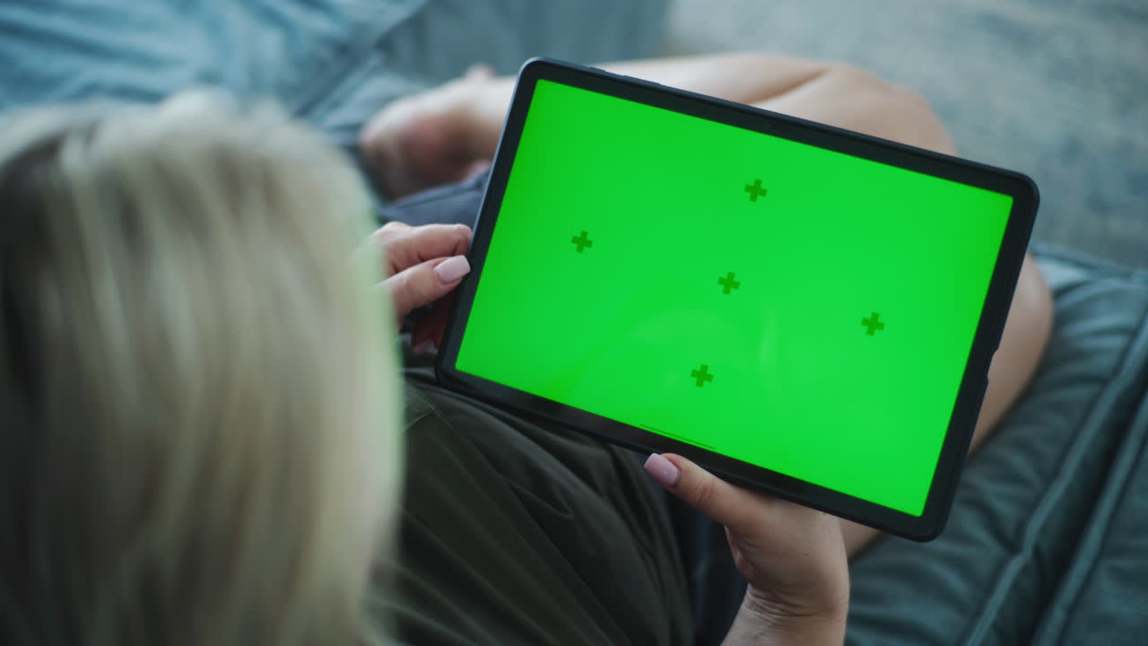 donna che usa un tablet con uno schermo verde