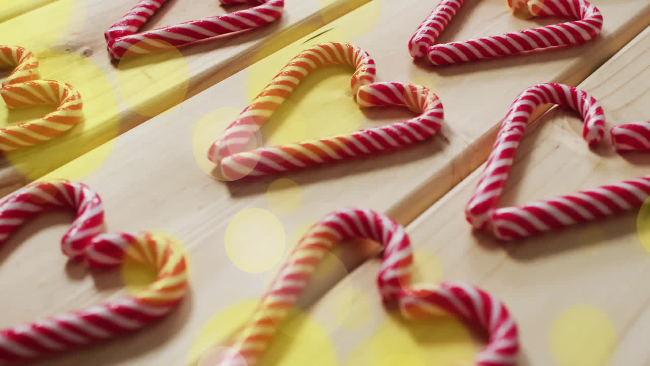 Cuori di bastoncini di zucchero su superficie di legno con animazione di luci bokeh