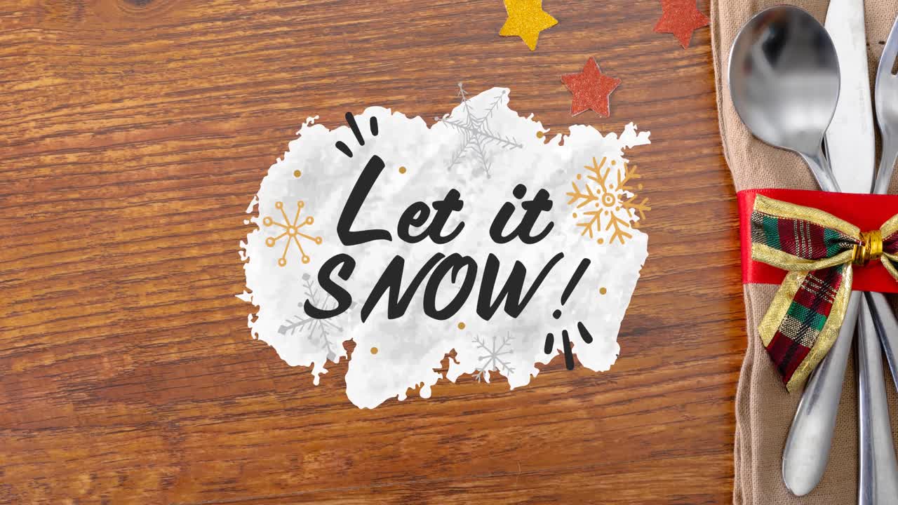Animation of let it snow christmas text and spoon on wooden table