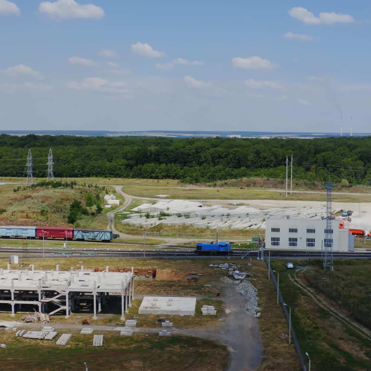 Industrial zone with freight train on a railway. Motion of cargo train on green nature background. Heavy cargo transportation harm to the environment.