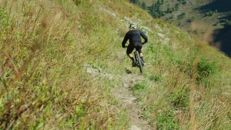 a cyclist rides down an alpine trail in autumn