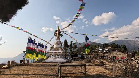 pueblo de montaña rural con estupa blanca y banderas de oración budista