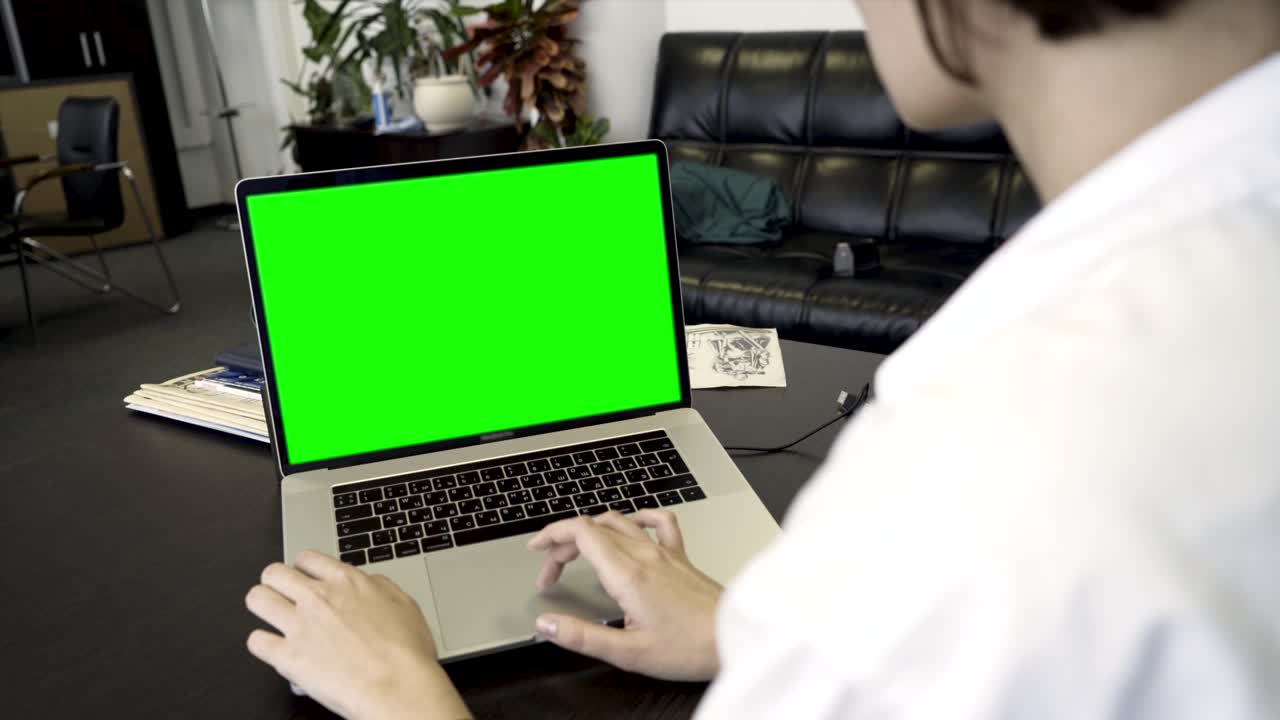 mujer trabajando en una computadora portátil con una pantalla verde