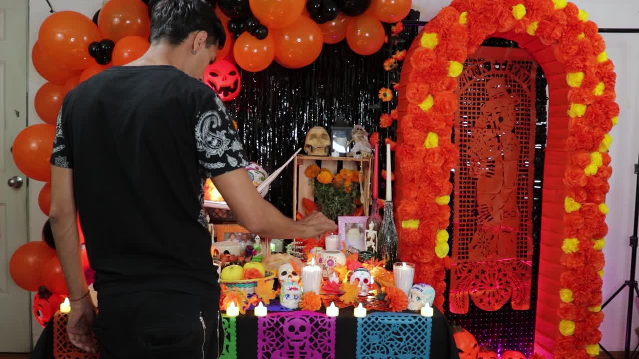 hombre mexicano encendiendo velas para los muertos en el altar del día de los muertos
