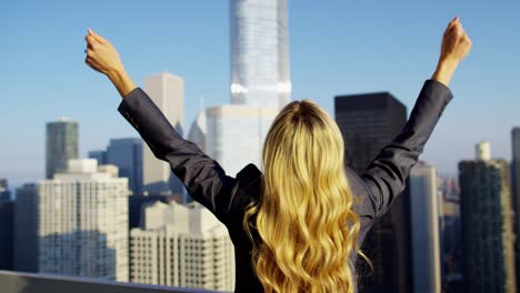 mujer de negocios americana caucásica en el techo con vistas a los rascacielos de chicago