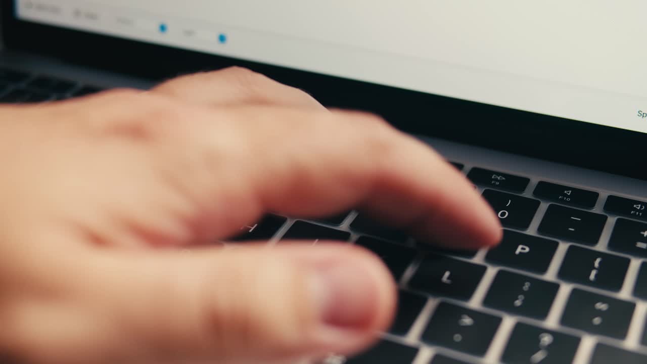Dedos tecleando en un teclado de portátil moderno
