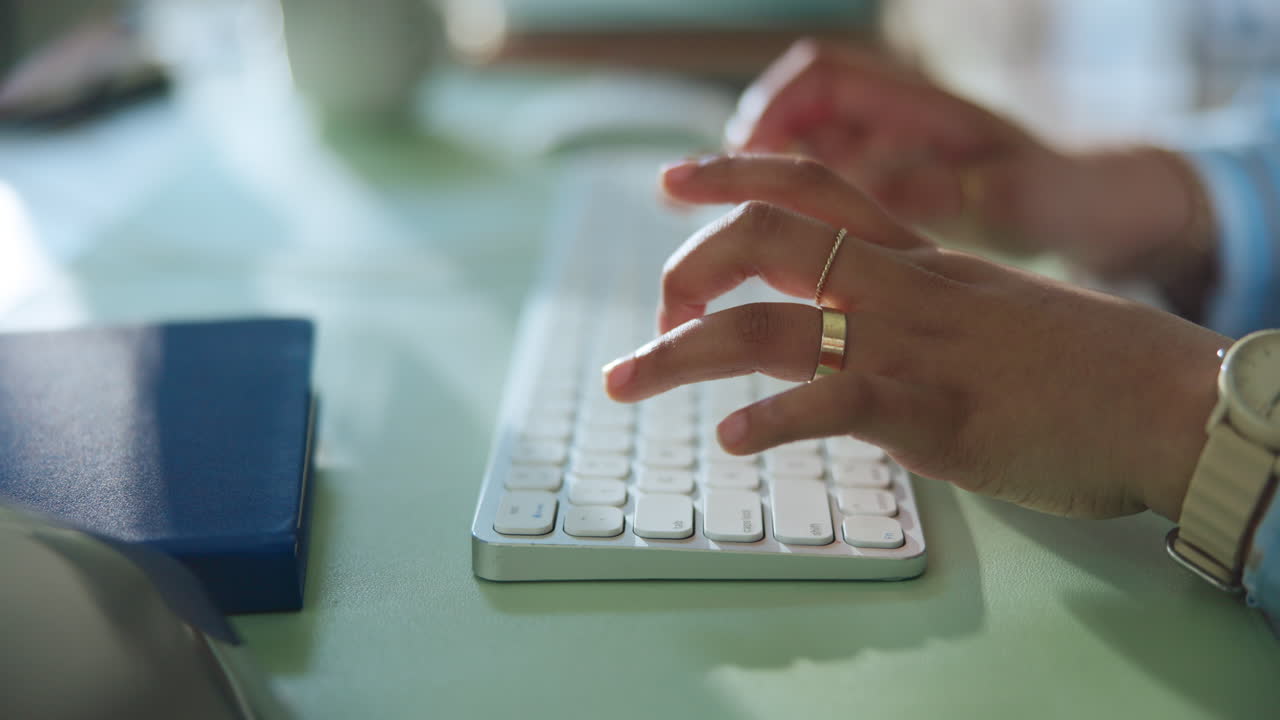 Nærbilde av hender som skriver på et moderne tastatur