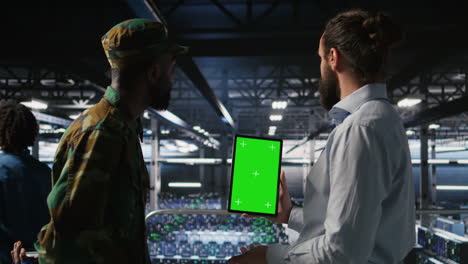military personnel overseeing ai computing operations on isolated screen tablet