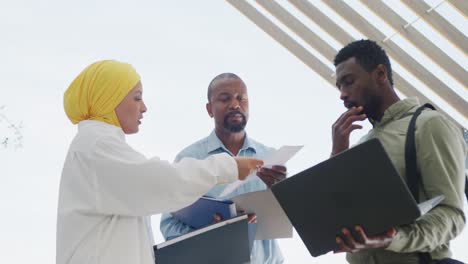 happy diverse business people discussing work and using laptop at office, slow motion