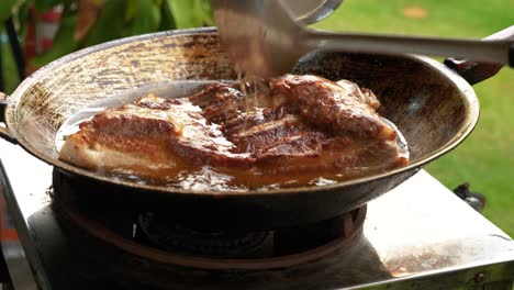 deep frying delicious and tender piece of pork belly, traditional thai cuisine