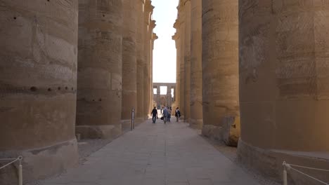 hand-held shot of tourists exploring the luxor temple and its pillars