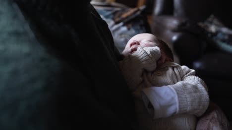 Senior-grandmother-holding-newborn-baby-in-the-couch